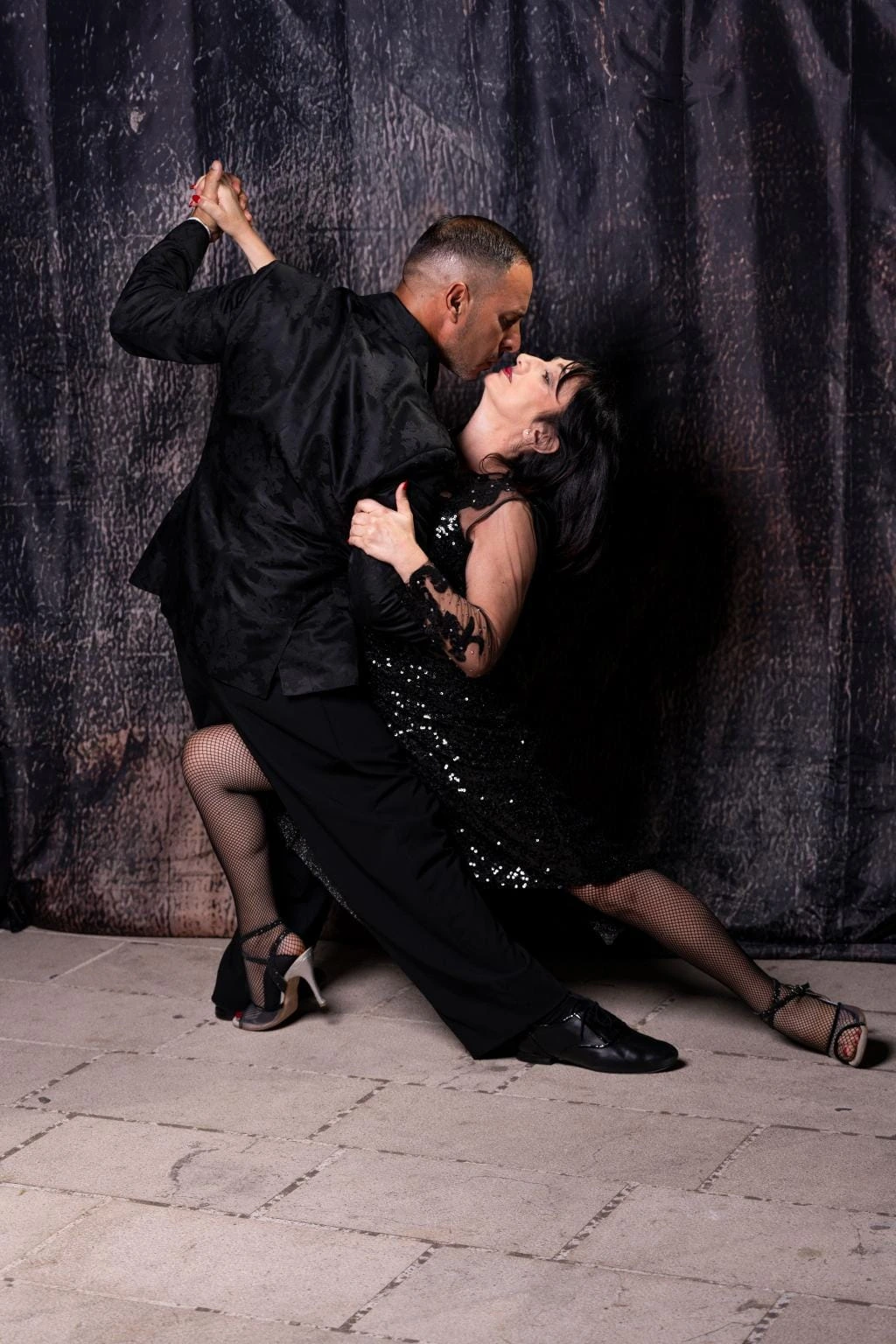 Coppia di tango in posa su fondo scuro
